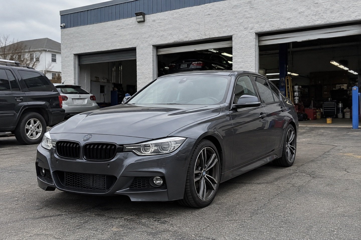 A graphite sport sedan outside the workshop after service